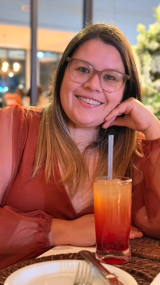 Ingrid Elisa sorrindo em um ambiente acolhedor