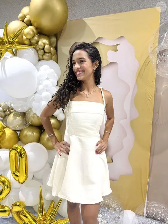 Duda Wilken sorrindo diante de uma decoração com balões
